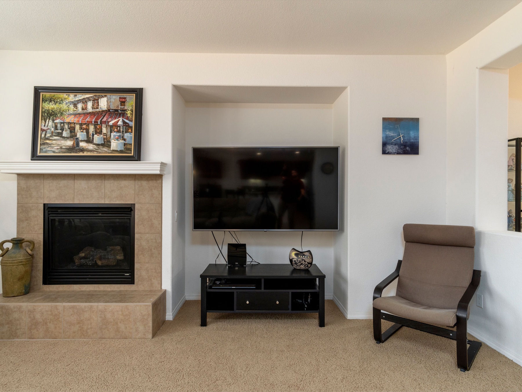 Living room interior with tiled fireplace, mantel, and wall-mounted television